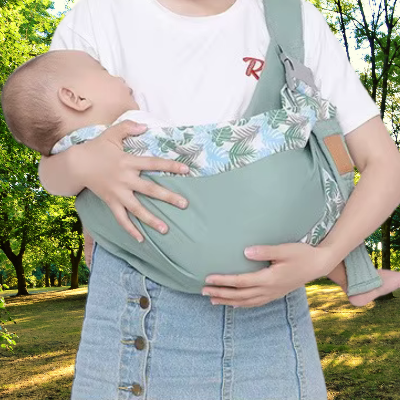 Bébé endormi dans écharpe de portage pendant une balade en nature.