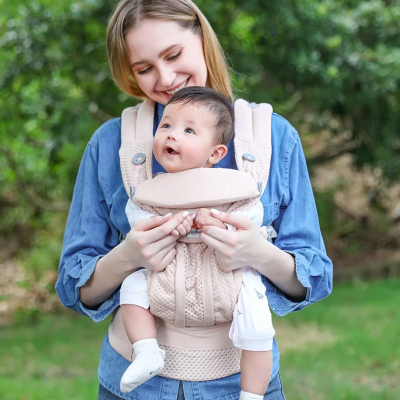 Maman porte son garçon avec porte bebe kangourou rose