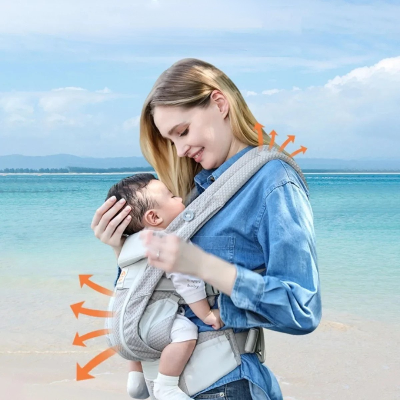 Maman-porte-son-garçon-avec-porte- bebe-kangourou-sur-une-plage